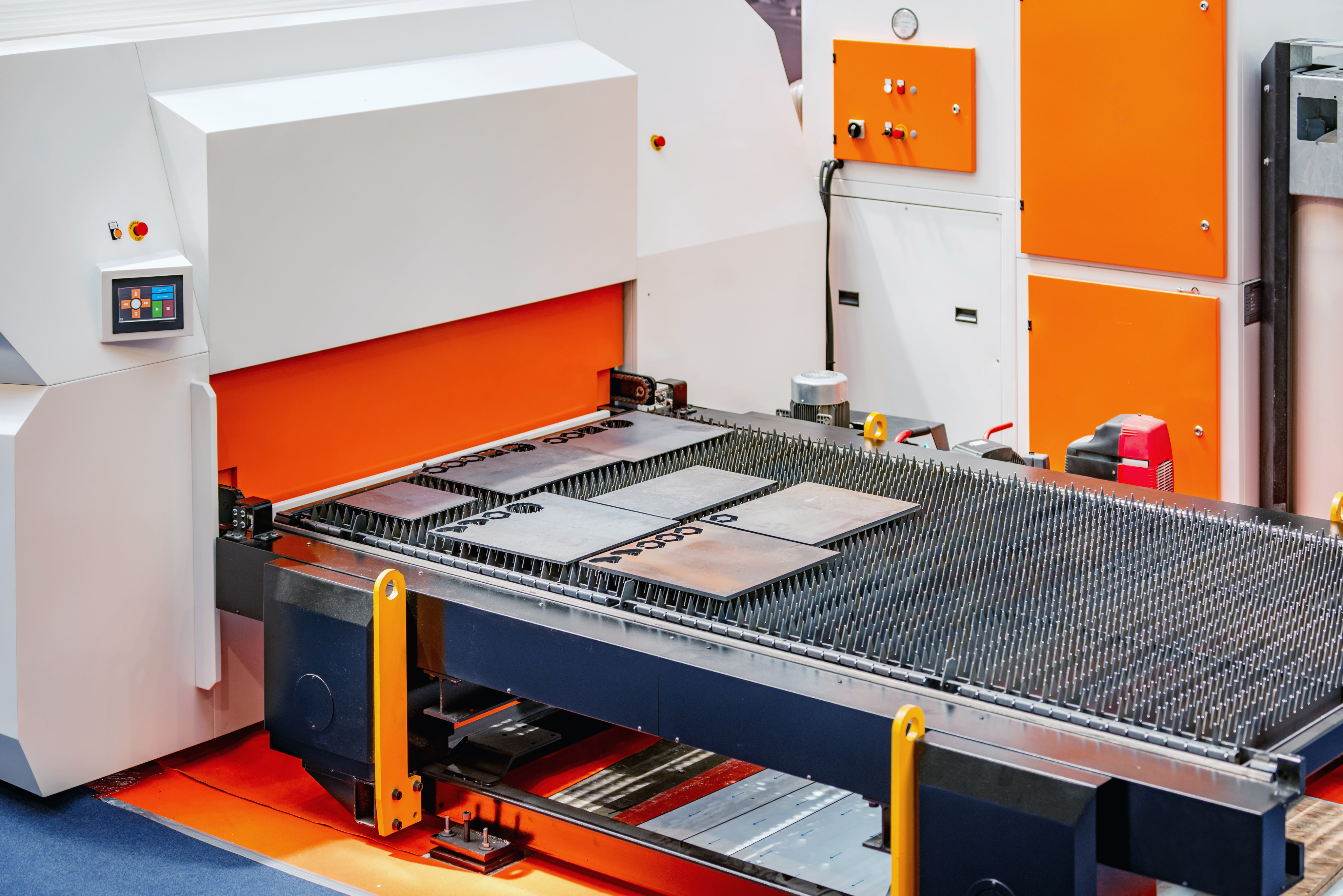 CNC turret punch press with sheet metal workpieces on worktable